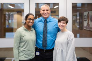 two students stand with principal