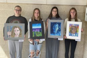students hold artwork