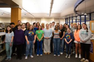 group of students stand in high school library