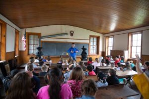 students sit in one-room schoolhouse
