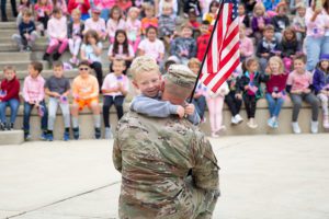 boy holds flag hugs dad
