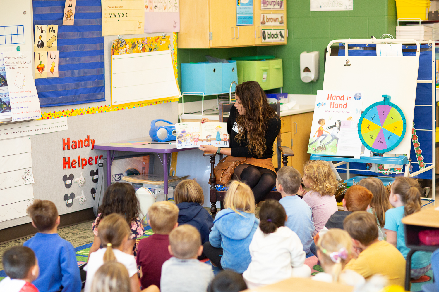 woman reading a book to kindergarten