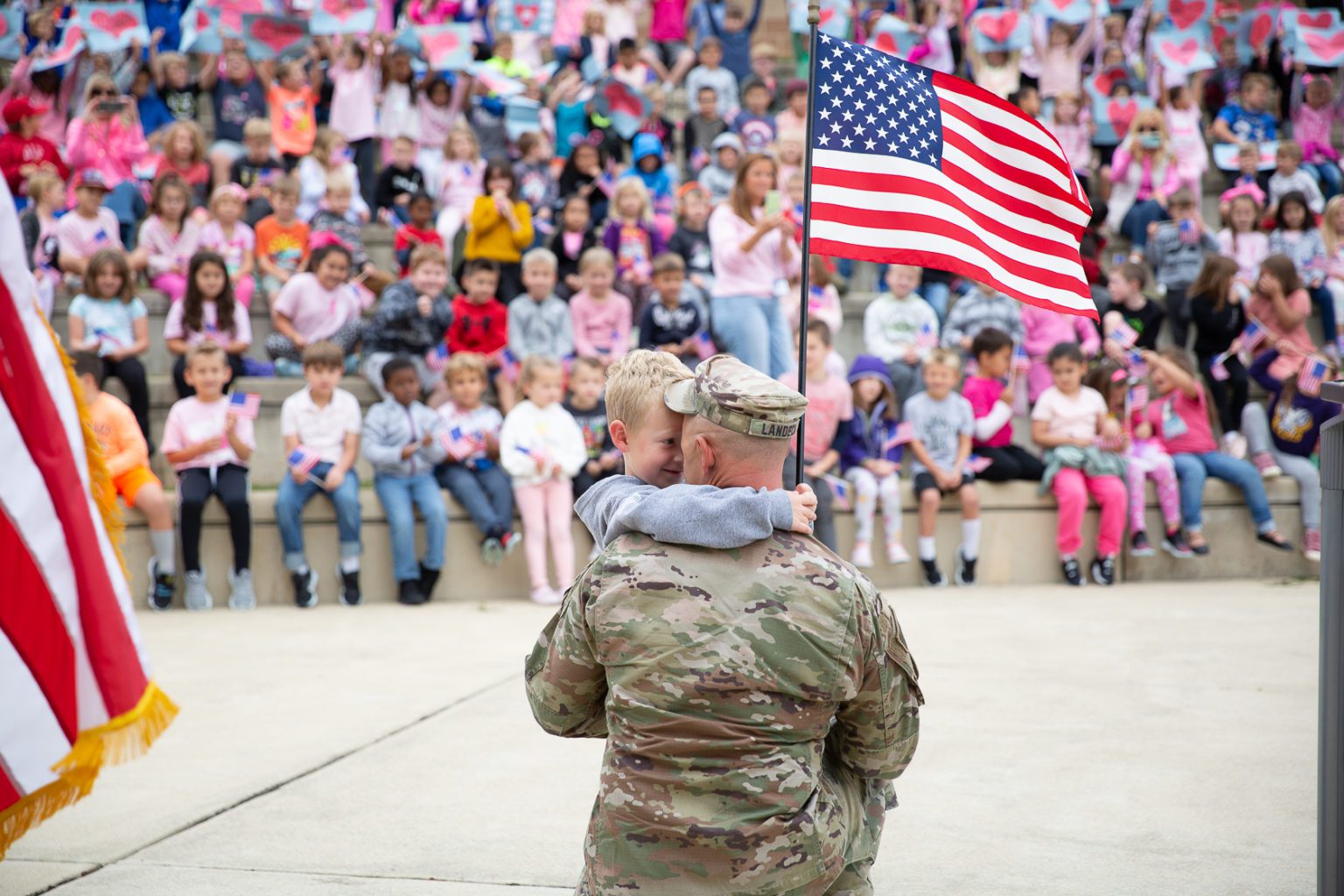 boy holds flag and hugs dad
