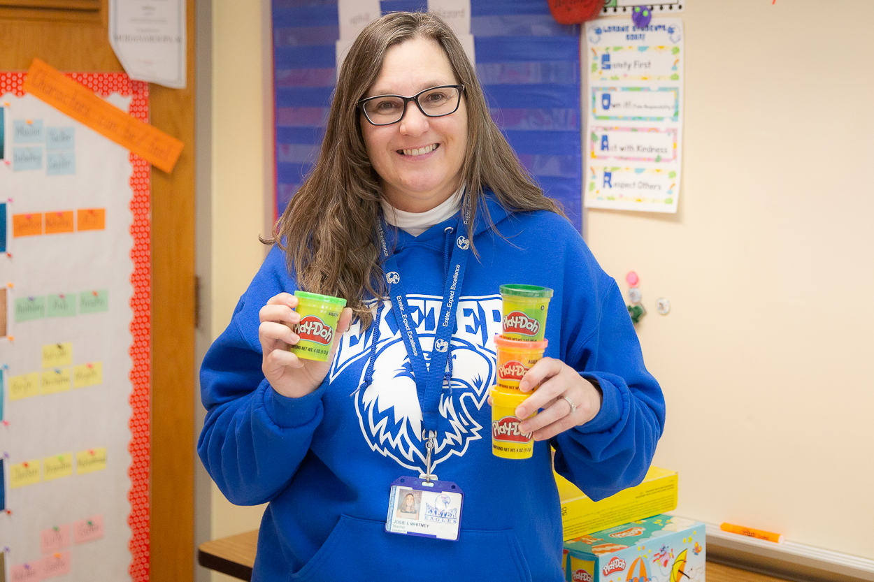 mrs whitney holds cans of playdoh