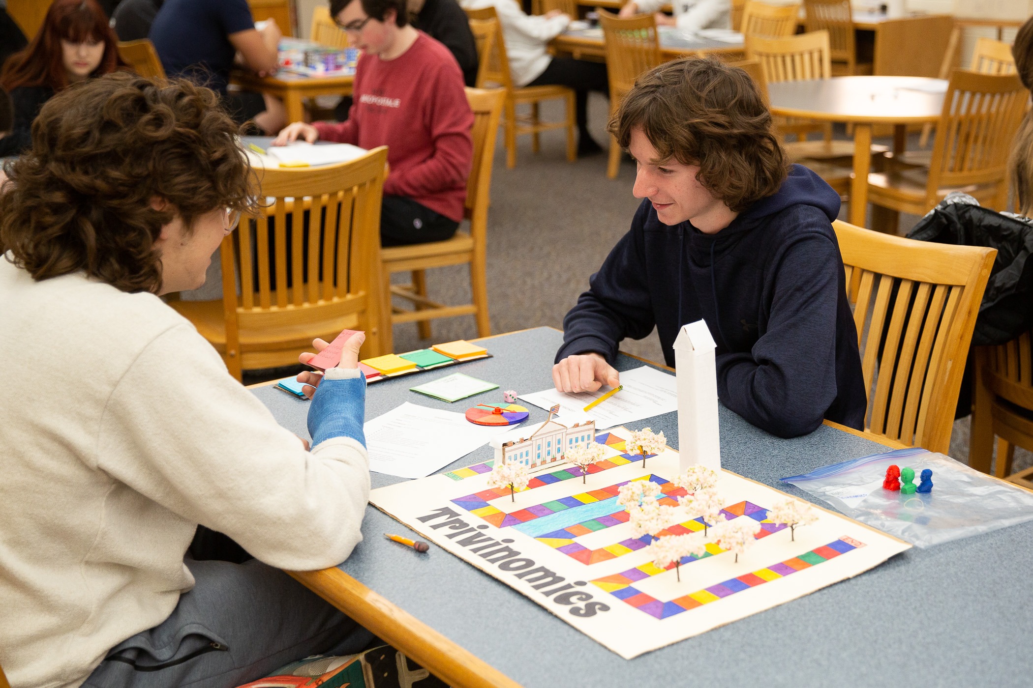 student play and discuss strategies over a board game