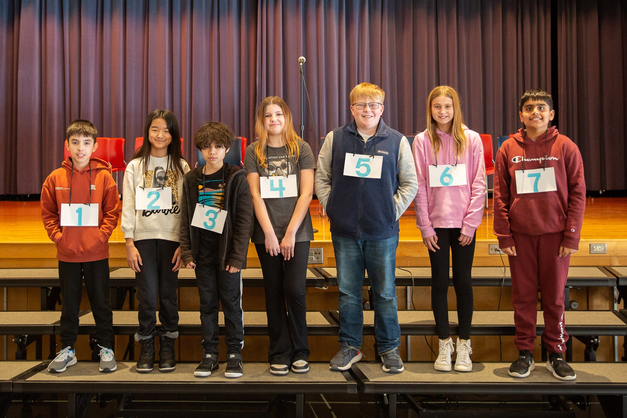 spelling bee students line up to compete in school auditorium