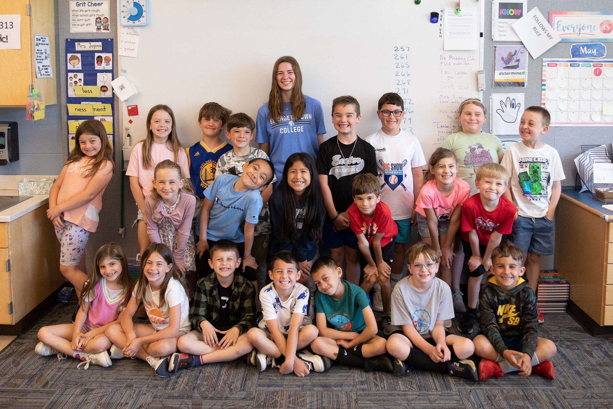 1R2A9545-2 a class of students pose in front of classroom's whiteboard