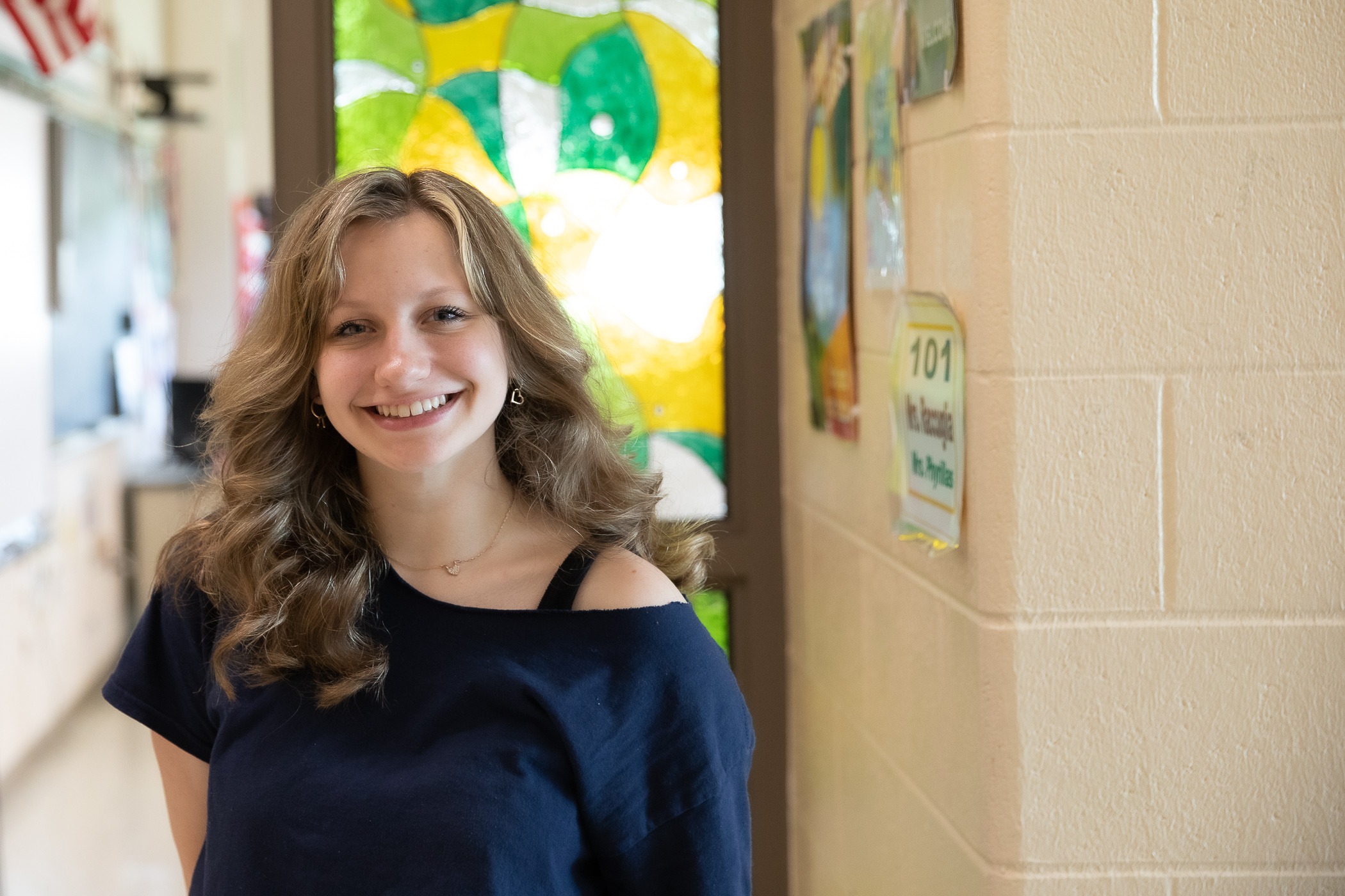 1R2A9764 a student stands outside of an empty classroom